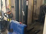 a forklift in a garage with a blue seat