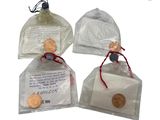 three small bags of soap sitting on top of a white surface