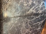 a black and white marble table with a clock on top of it