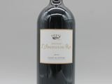 une bouteille de vin rouge posée sur une table blanche