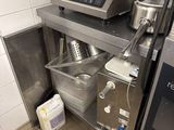 une petite cuisine équipée d'une cuisinière, d'un évier et d'autres appareils électroménagers