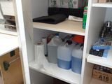 a white cupboard with lots of bottles and containers on it