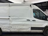 a white van that has been vandalized in a garage