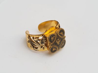 a close up of a gold ring on a white surface