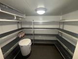 a white bucket sitting in the middle of a pantry