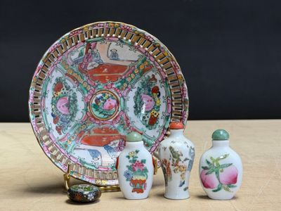 three small vases sitting next to a plate on a table