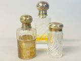trois flacons de parfum posés l'un à côté de l'autre sur une table