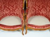 two red chairs that are sitting next to each other