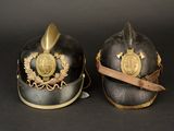 pair of helmets with gold decoration on them on a black background