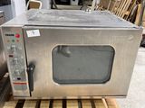 a silver microwave sitting on a pallet in a warehouse