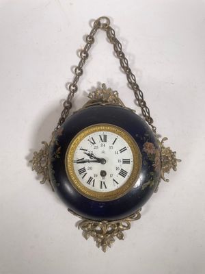 une horloge suspendue à une chaîne au mur