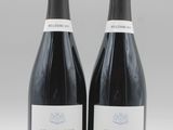 deux bouteilles de vin sont posées l'une à côté de l'autre sur une table