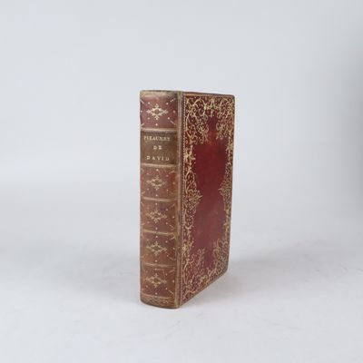 un livre rouge posé sur une surface blanche