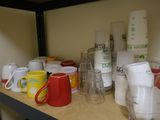 many cups and pitchers on a shelf in the kitchen