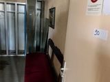a bench in the hallway of a building with a no smoking sign on the wall