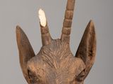 a wooden sculpture of a goat with horns on it ' s head