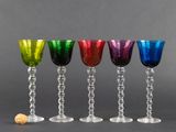quatre verres à vin de couleurs différentes posés les uns à côté des autres sur une table