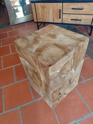a wooden box sitting on a brick floor next to a dresser