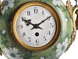 a green and white vase with a clock on it