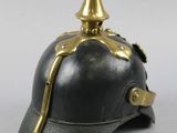 an old helmet with a gold spiked top on a white background