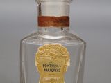 un vieux flacon de parfum à l'étiquette dorée posé sur une table