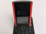 a black and red cell phone sitting on a stand