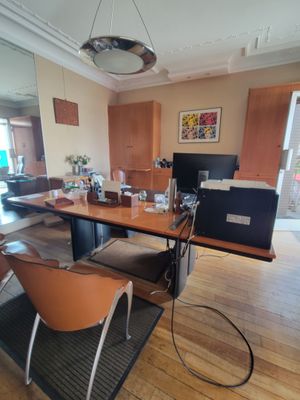 a desk with a computer and a chair in the room