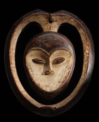 gros plan d'un masque en bois accroché au mur