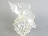 un vase en verre avec une fleur à l'intérieur sur une table
