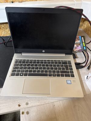un ordinateur portable ouvert posé sur un bureau en bois