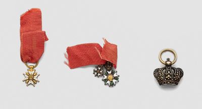 three medals and a crown on a white surface
