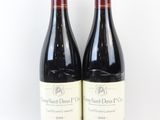 deux bouteilles de vin rouge posées l'une à côté de l'autre sur une surface blanche