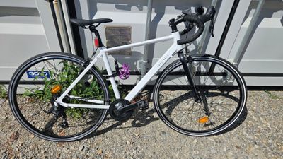 un vélo blanc garé à côté d'un immeuble
