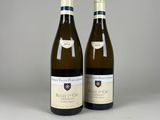 deux bouteilles de vin blanc posées l'une à côté de l'autre sur une table