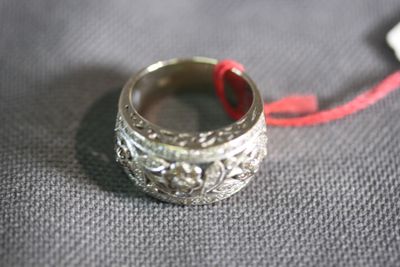a silver ring with a red string attached to it
