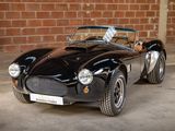 a black sports car parked in front of a brick wall