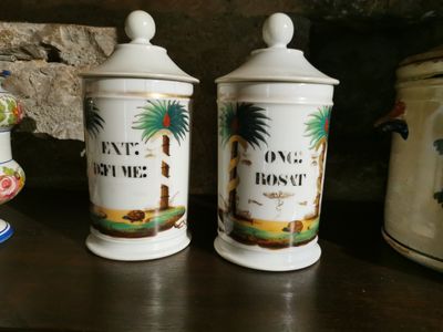 two ceramic containers on a table with a stone wall in the background