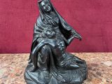une statue de femme assise au sommet d'un rocher