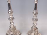 pair of silver candlesticks with ornate designs on each of them