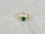 a close up of a gold ring with a green stone