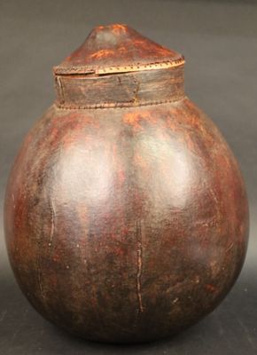 un vase marron muni d'un couvercle, posé sur une table