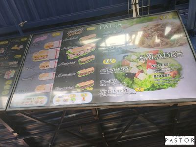 un grand panneau présentant le menu, fixé sur le côté d'un immeuble