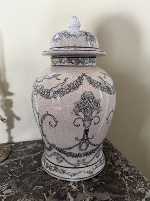 un vase blanc et bleu avec un couvercle, posé sur une table