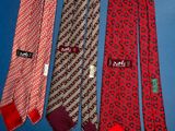 three ties with different designs on them hang on a blue background