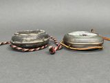 two silver objects that are on a gray surface