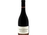 a bottle of red wine sitting on top of a white table