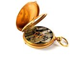a gold pocket watch that is open on a white surface