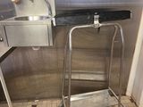 un évier en inox et un tabouret en métal dans une cuisine