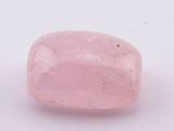 une pierre de quartz rose posée sur une surface blanche