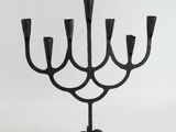 a black iron candelab with five candles on a stand